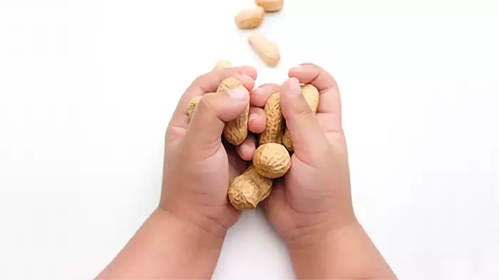 Le mani di un bambino stringono una manciata di arachidi