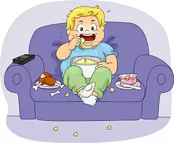 Un ragazzino in sovrappeso chiuso in casa per il coronavirus è seduto sul divano, guarda la TV e si ingozza di cibo spazzatura