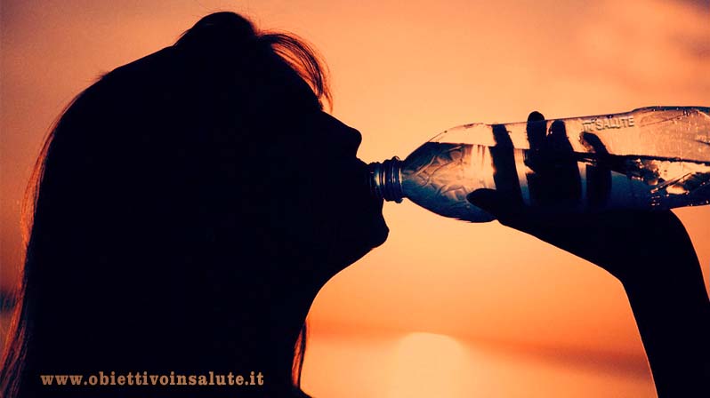 Donna beve dell'acqua dalla bottiglia