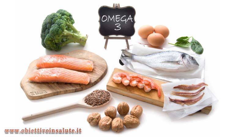 Tavola con un cartello dove c'è scritto "Omega 3" e diversi alimenti come salmone, orata, uova, gamberi, cavolo, noci ecc.