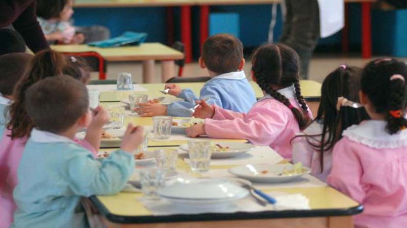 Bambini pranzano nella mensa della scuola