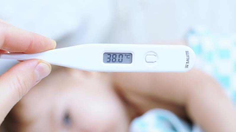 Mamma misura la febbre, col termometro digitale, al proprio bambino