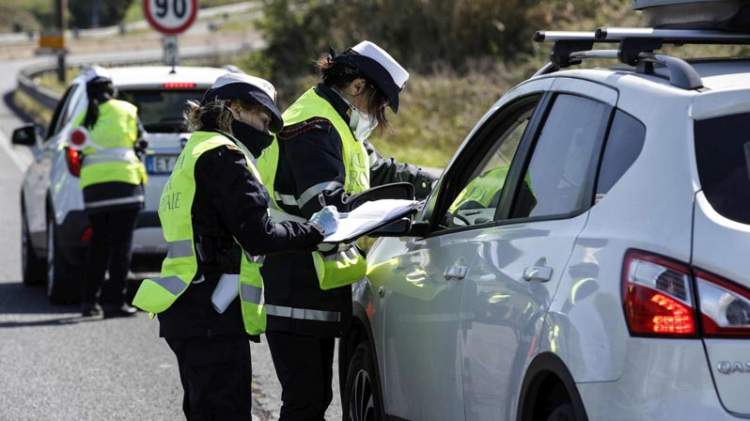 Due vigilesse con la mascherina controllano le autocertificazioni di alcuni automobilisti