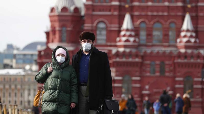 Covid-19 Russia, una coppia con la mascherina davanti al Cremlino