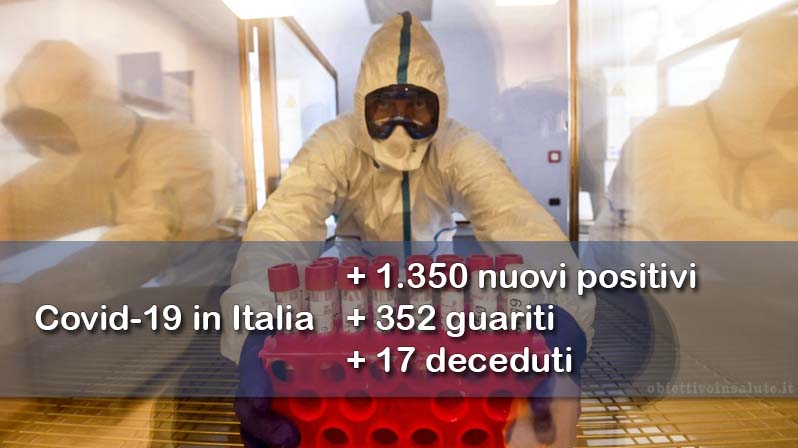 Un infermiere preleva delle provette dalla cella frigorifera, in primo piano dell’immagine vengono riportati i dati aggiornati del contagio in Italia