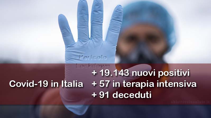 Un'infermiera mostra il palmo della mano ricoperta da un guanto medico con su scritto &quot;pericolo lockdown&quot;, in primo piano dell’immagine vengono riportati i dati aggiornati del contagio in Italia