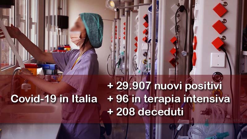 Delle infermiere prestano assistenza presso una terapia intensiva covid, in primo piano dell’immagine vengono riportati i dati aggiornati del contagio in Italia