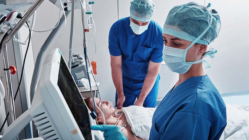 Due infermieri si prendono cura di una paziente in terapia intensiva