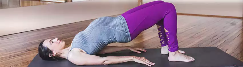 Donna incinta che fa ginnastica sdraiata a terra di schiena